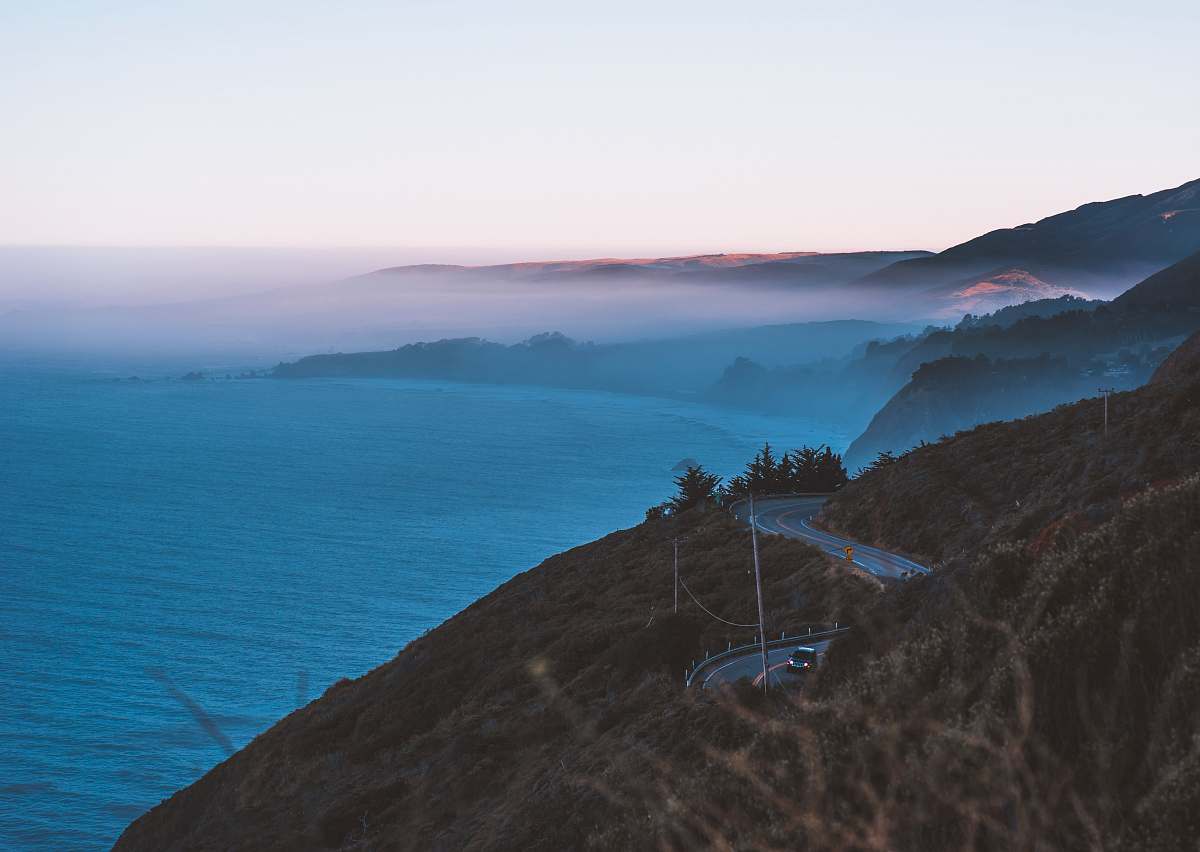 nature body of water and road hills surrounded by fogs big sur